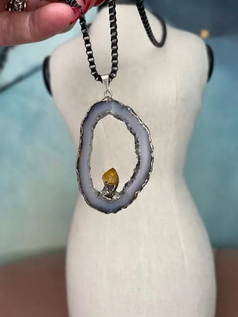 Robyn Rhodes Necklace that is an Oval Grey Agate interior lines with Clear and Black Druzy including a Citrine nugget